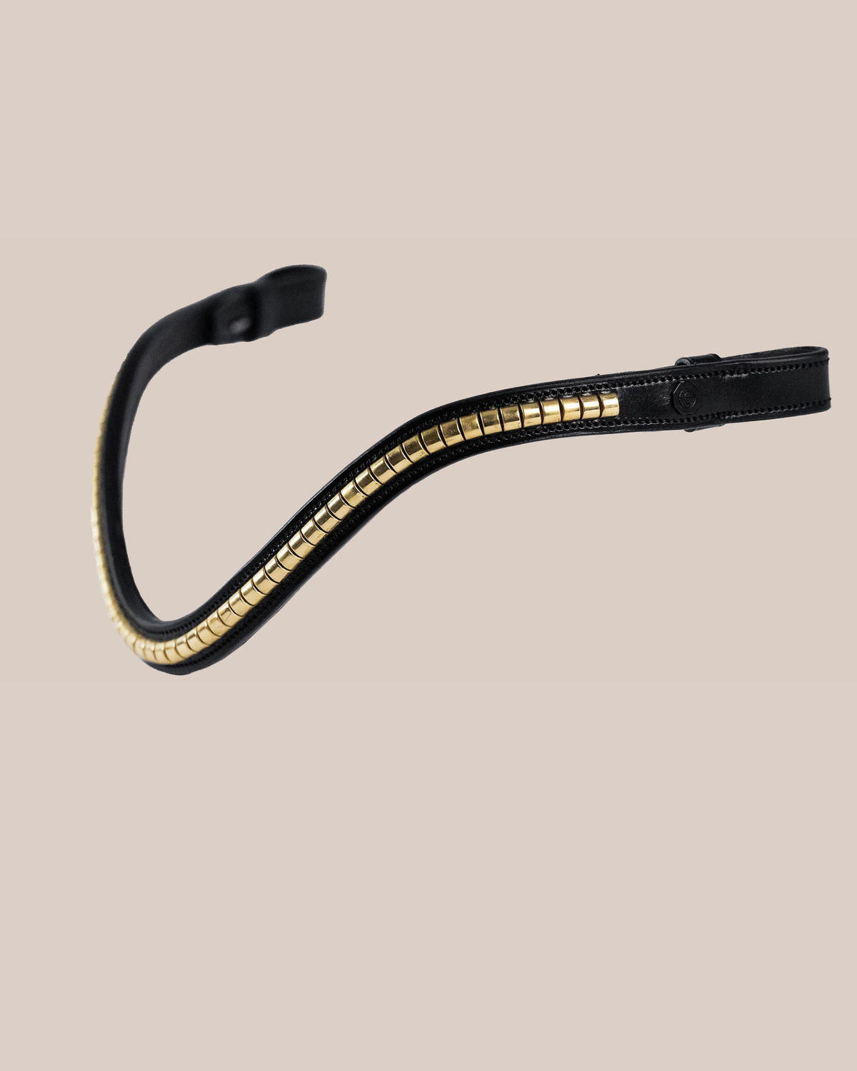 Black leather bridle with gold accents on a beige background