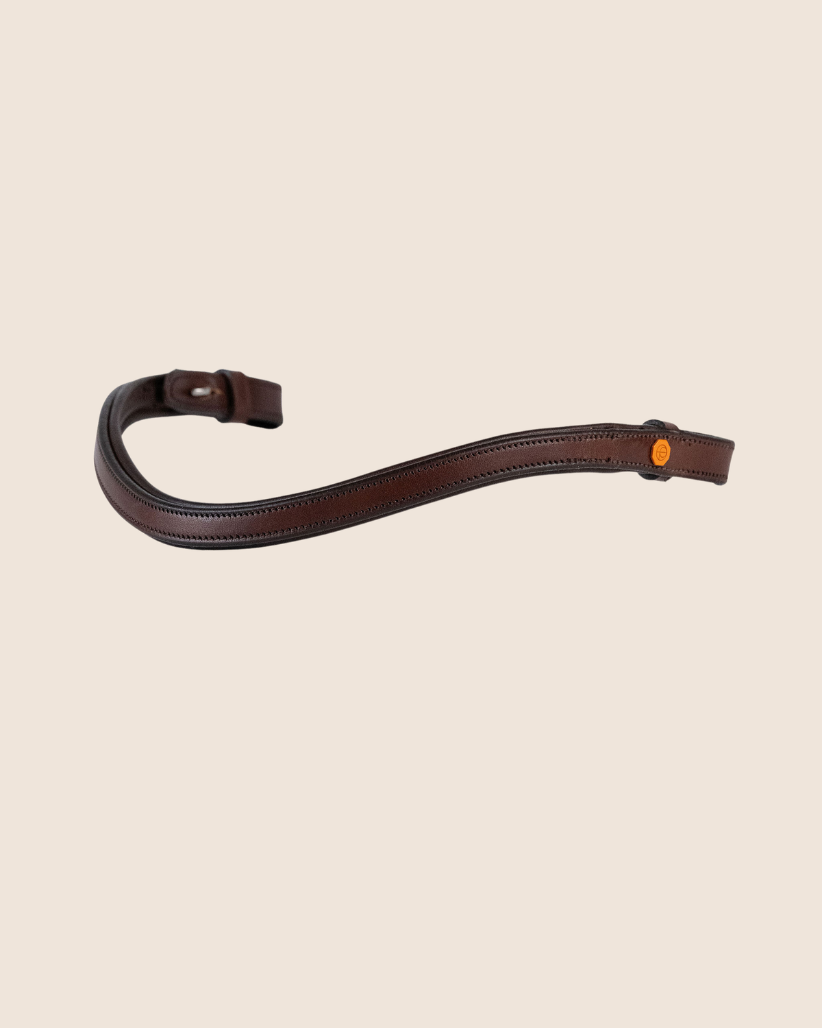 Brown leather strap with a buckle on a beige background