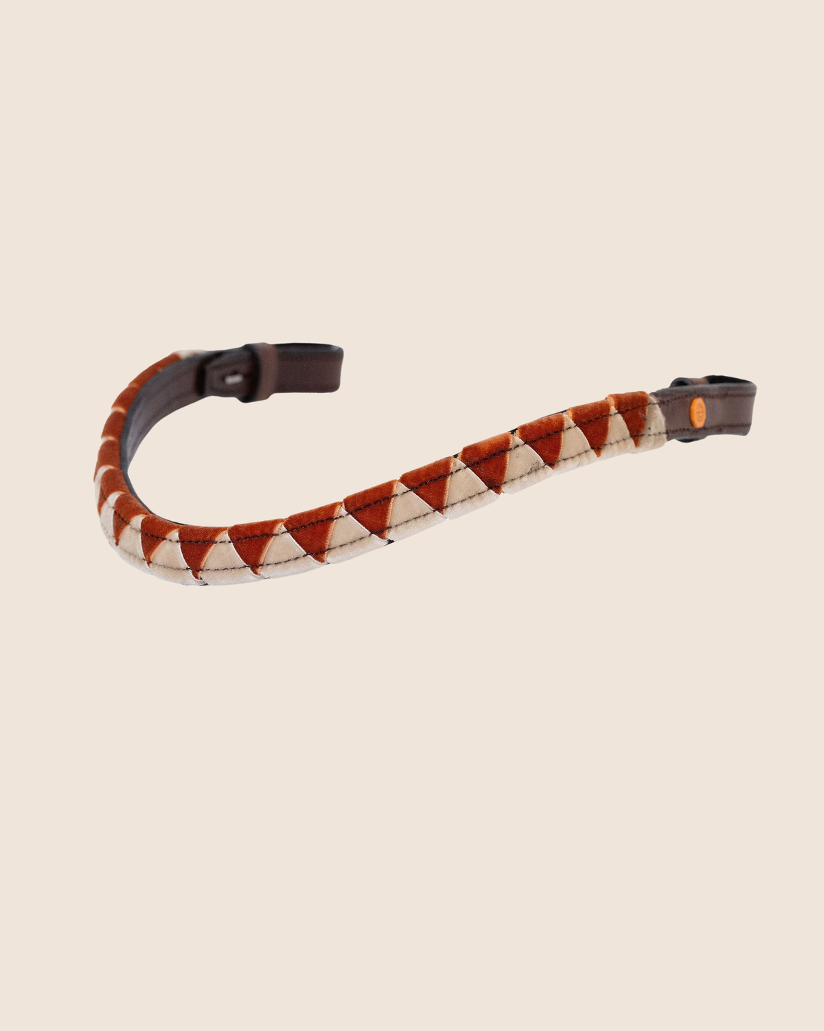 Camera strap with brown and beige pattern on a beige background